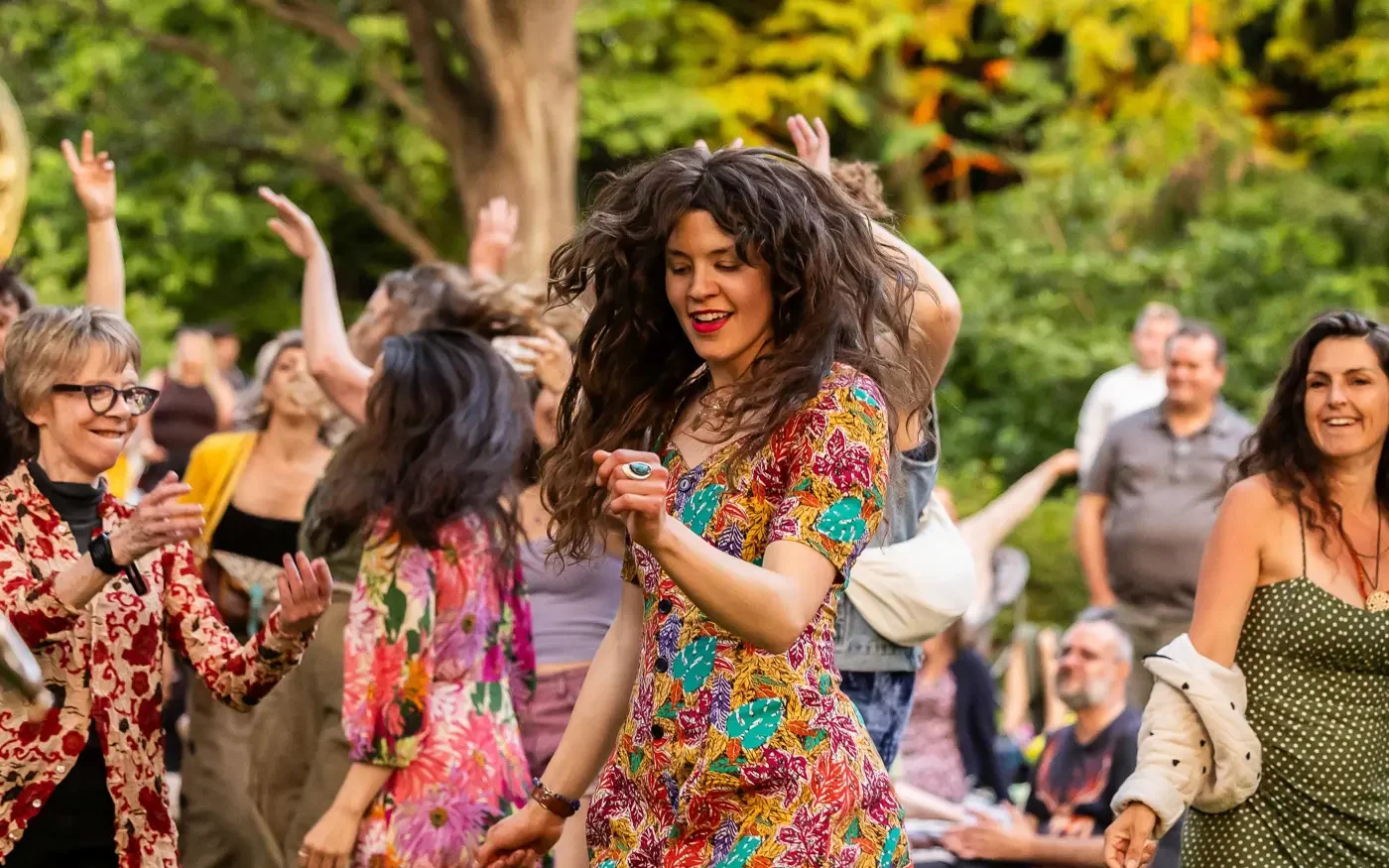 People dressed in colourful attire dancing and enjoying a gathering
