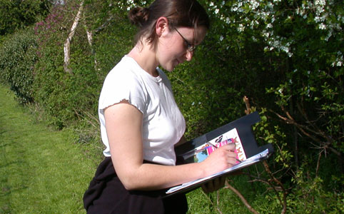 A woman holding a clipboard writing down the butterflies she sees on a walk along a hedgerow.